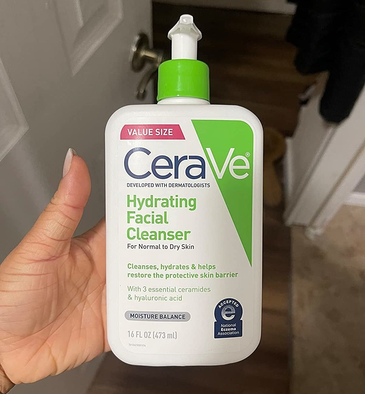 Reviewer holding bottle of cleanser