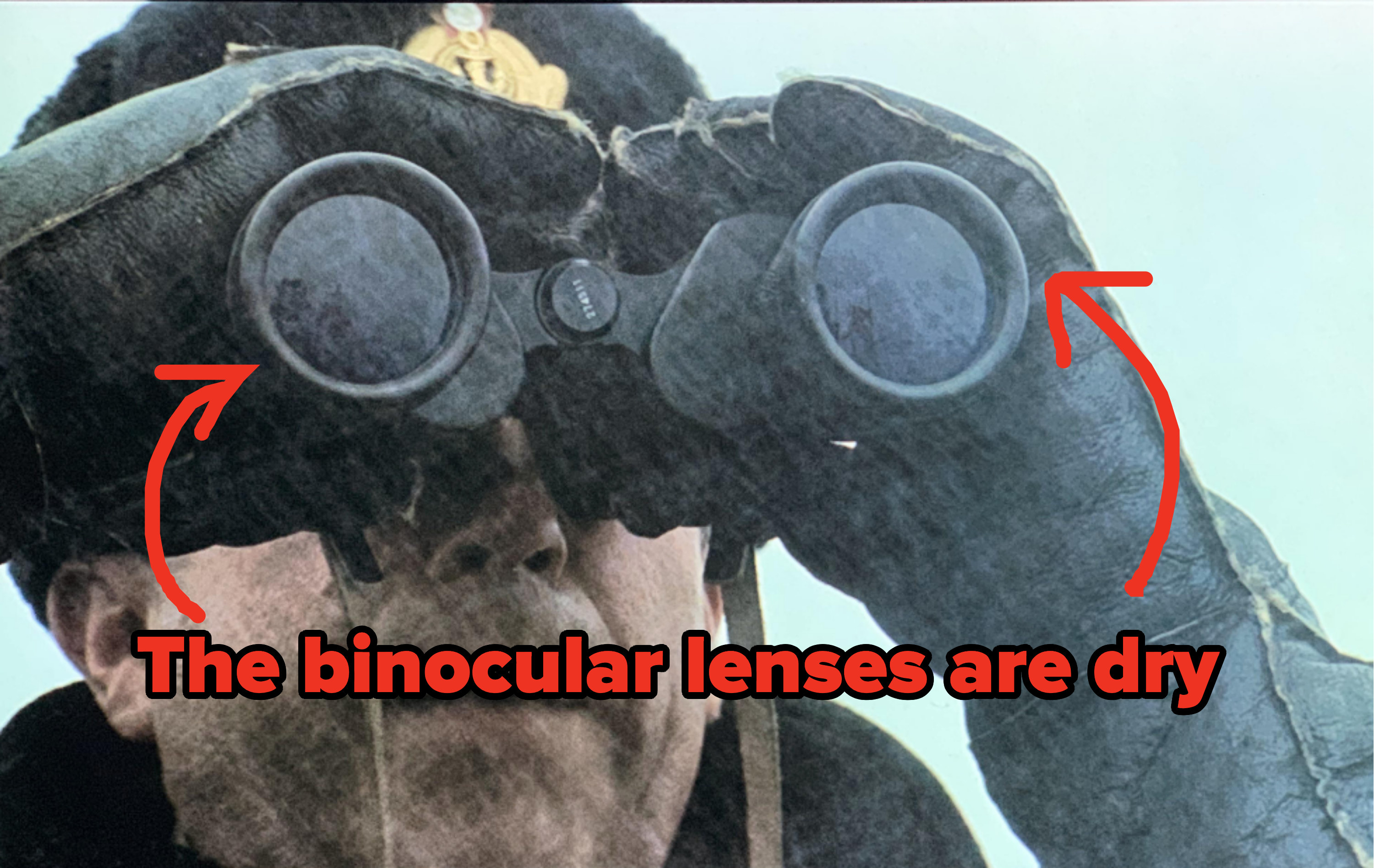 A character is using binoculars in a rainstorm, but the binocular lenses are dry