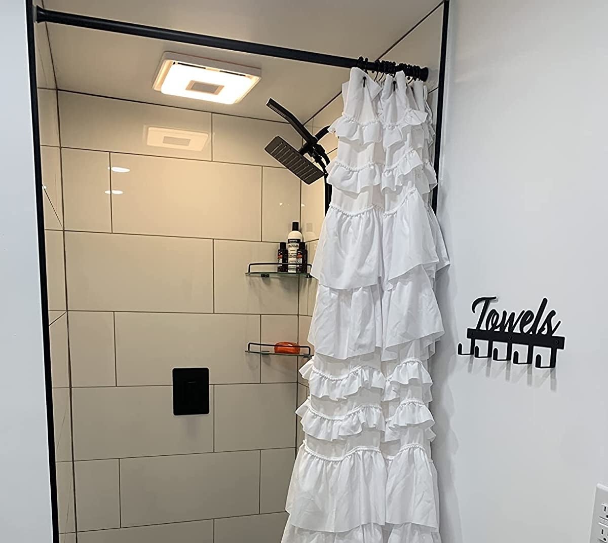 Reviewer image of white shower curtain hanging on a black rod in their bathroom