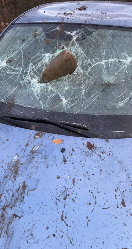 A large rock fell on a car, badly cracking its windshield
