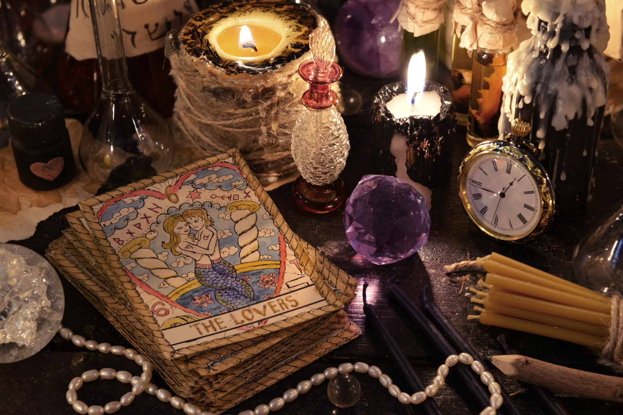 table with tarot cards, crystals, and candles