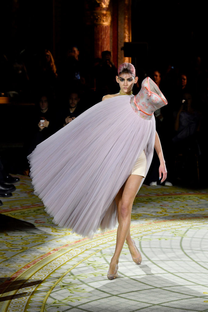 model walking with a dress attached to her diagonally