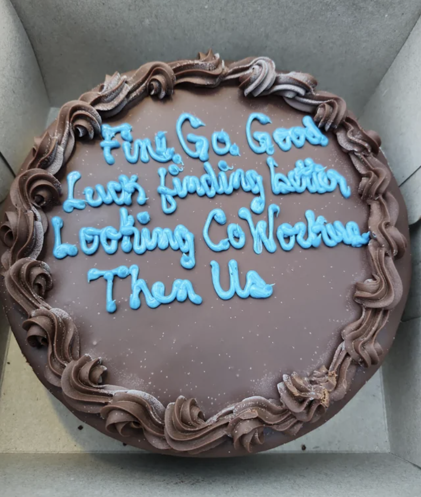 &quot;Fine, go, good luck finding better-looking coworkers than us&quot; written on a chocolate cake