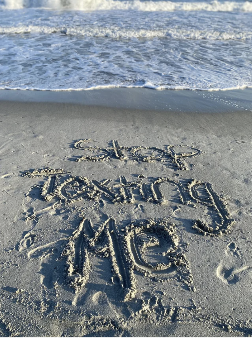 &quot;Stop texting me&quot; written in the sand