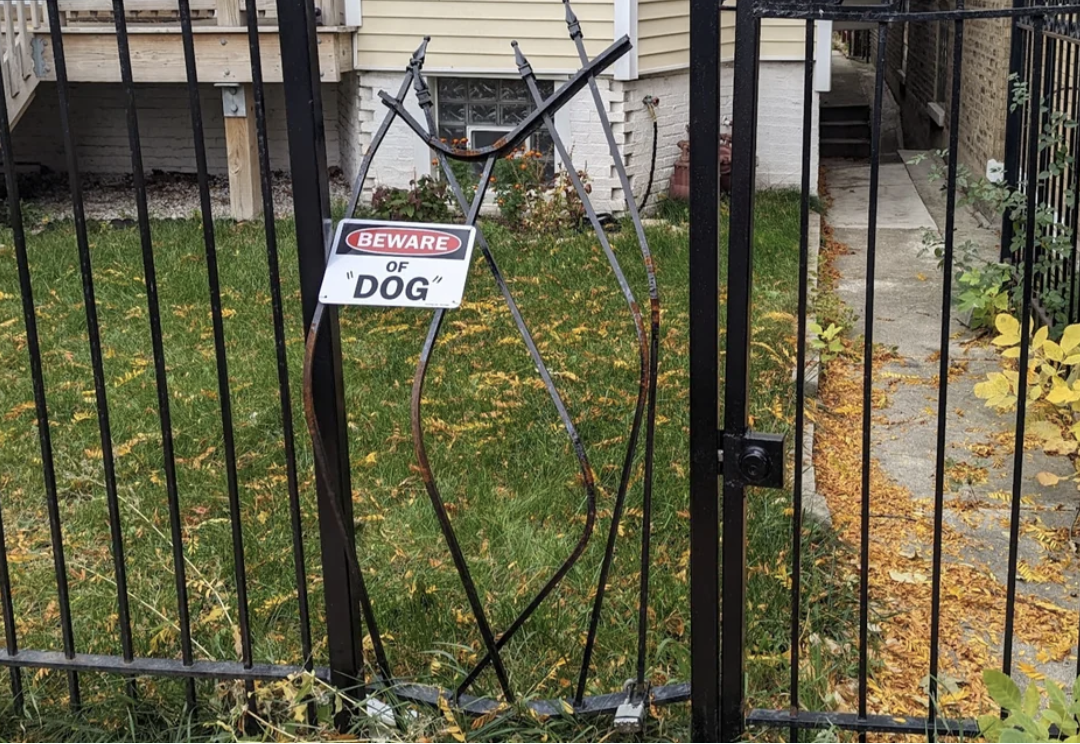 Beware of &quot;dog&quot; sign on a broken fence (with &quot;dog&quot; in quotation marks)