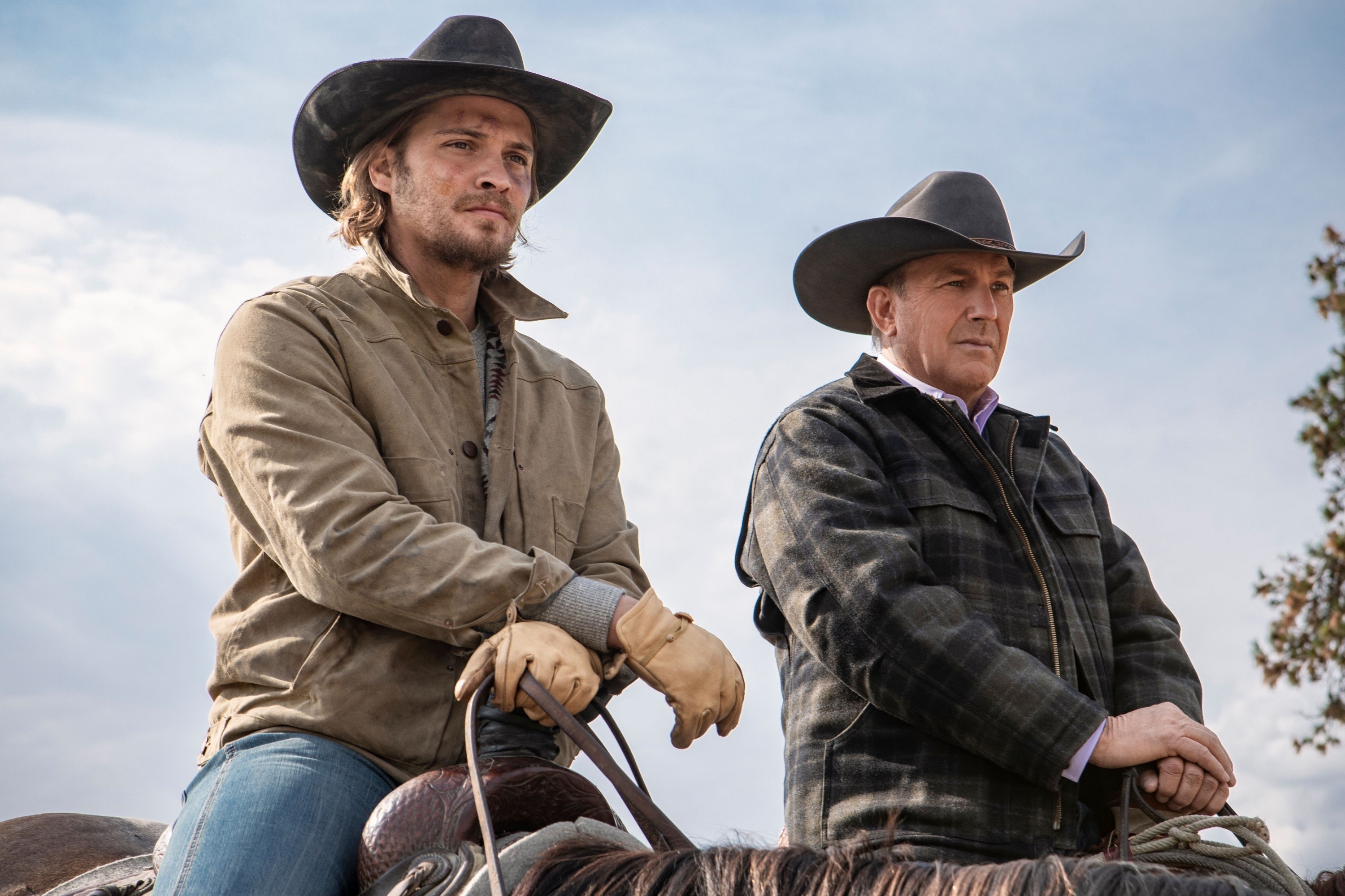 Luke Grimes and Kevin Costner next to each other on horses