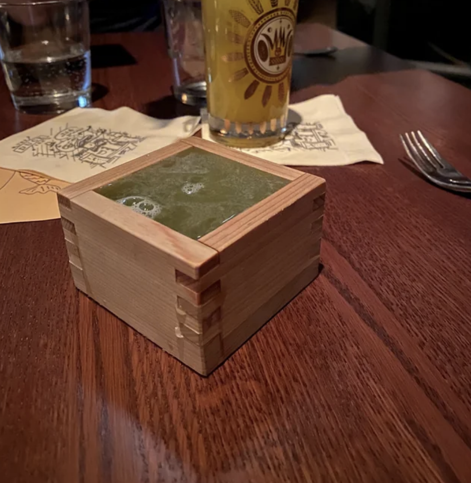 Liquid in a wooden box that looks like a Jenga piece