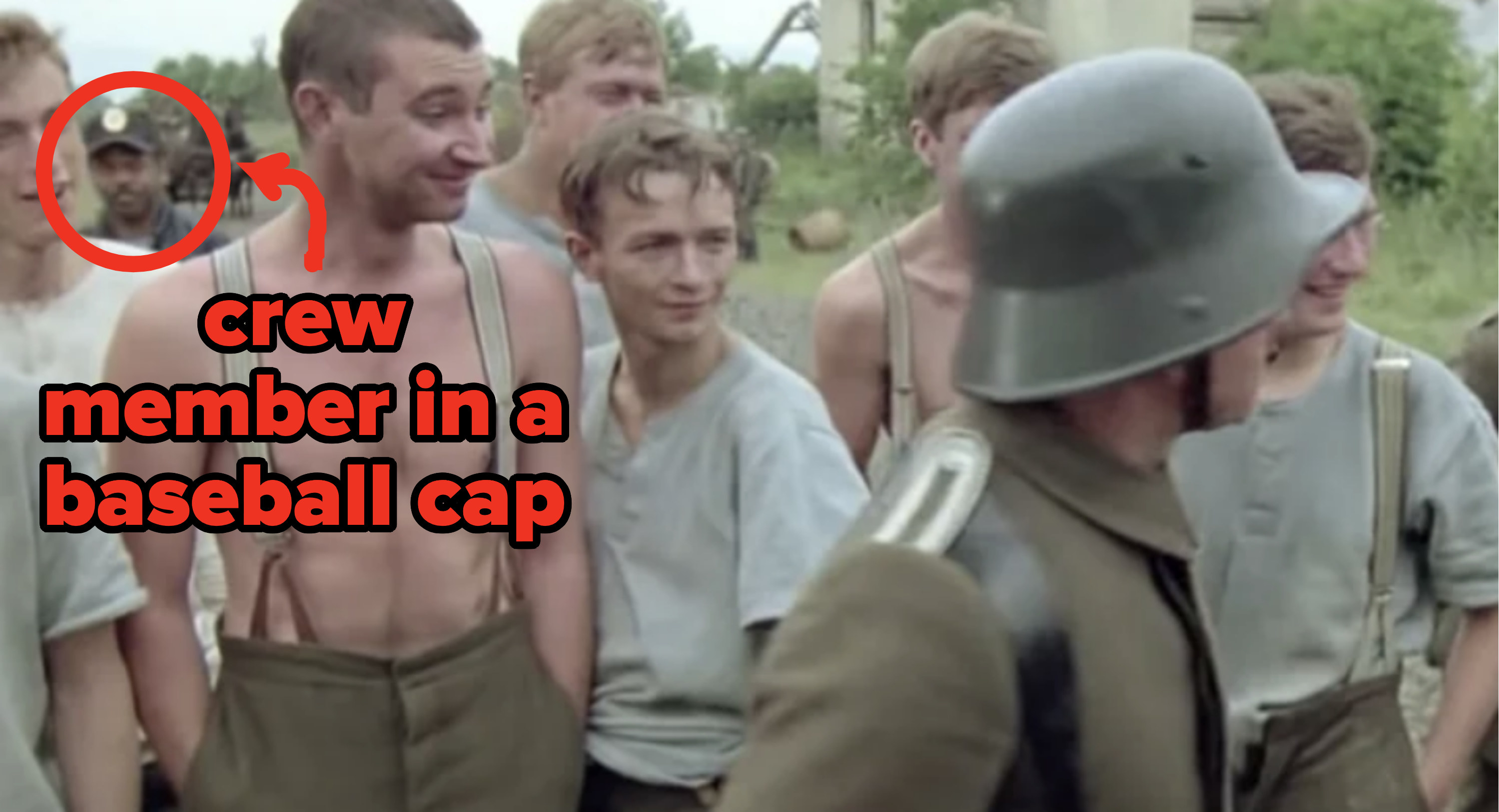 In a war scene full of actors wearing period appropriately military gear, you can clearly see a modern crew member in the background wearing a baseball cap