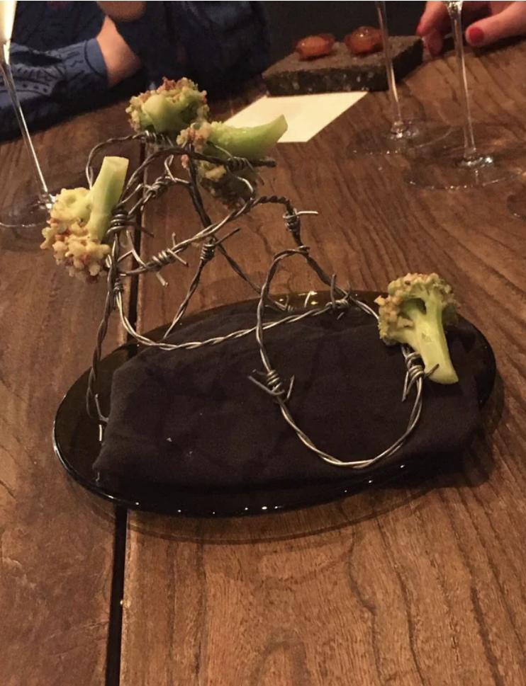 Broccoli florets stuck on what looks like barbed wire