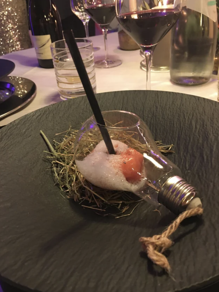 Sorbet with foam served with a straw inside a broken light bulb
