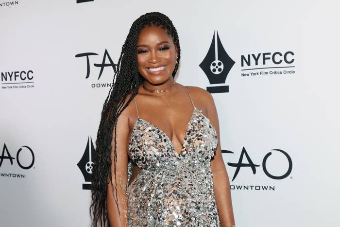 Keke smiles at a red carpet event wearing a sequined spaghetti strap dress