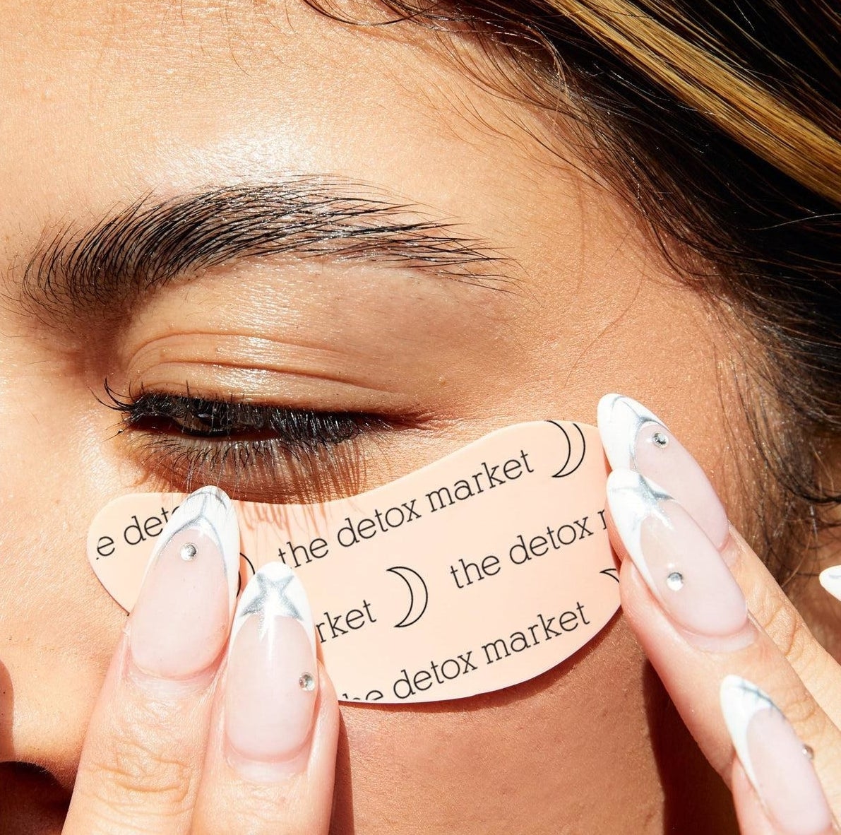 a person applying one of the reusable undereye patches