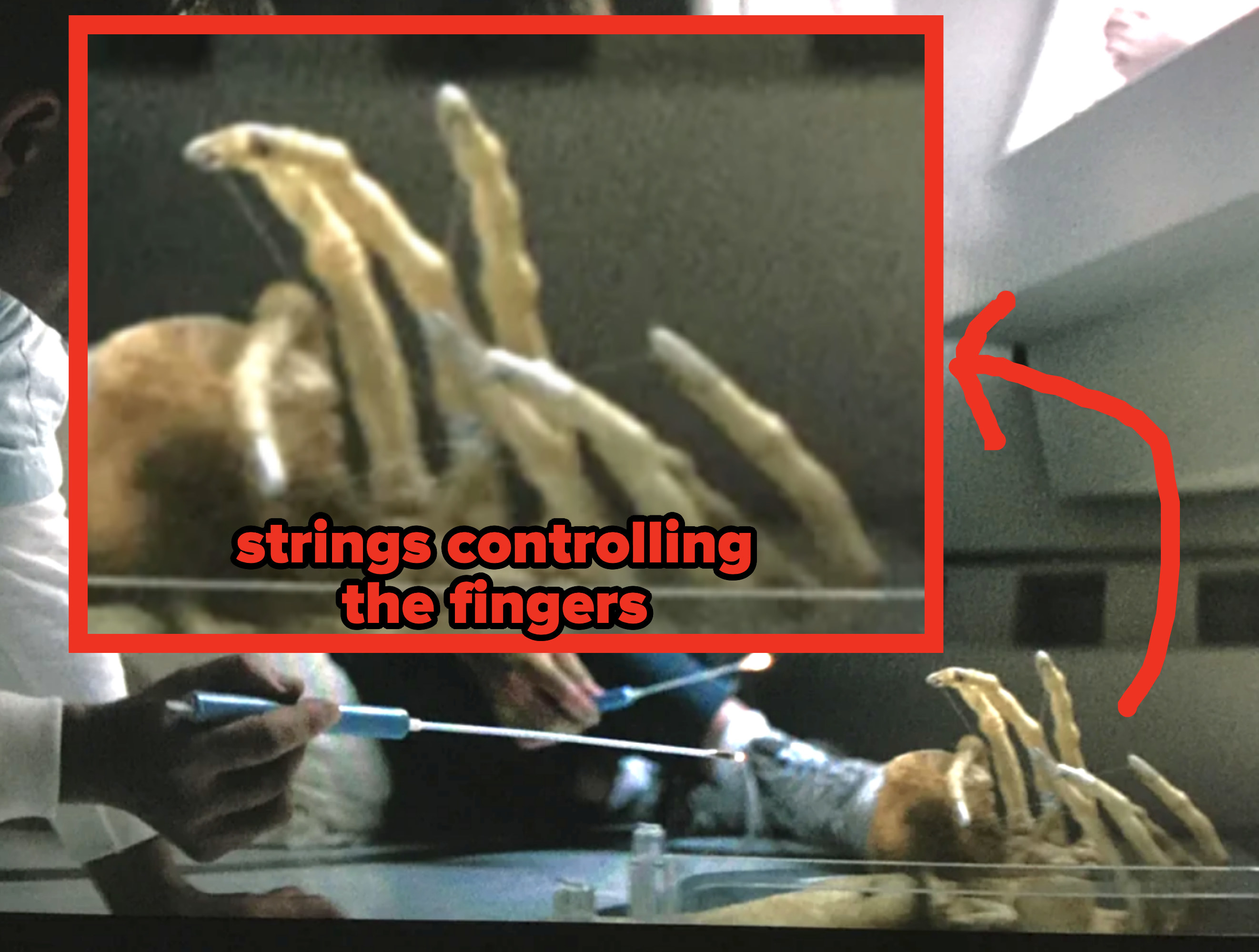 You can faintly see the strings being used to control the alien&#x27;s fingers like a marionette