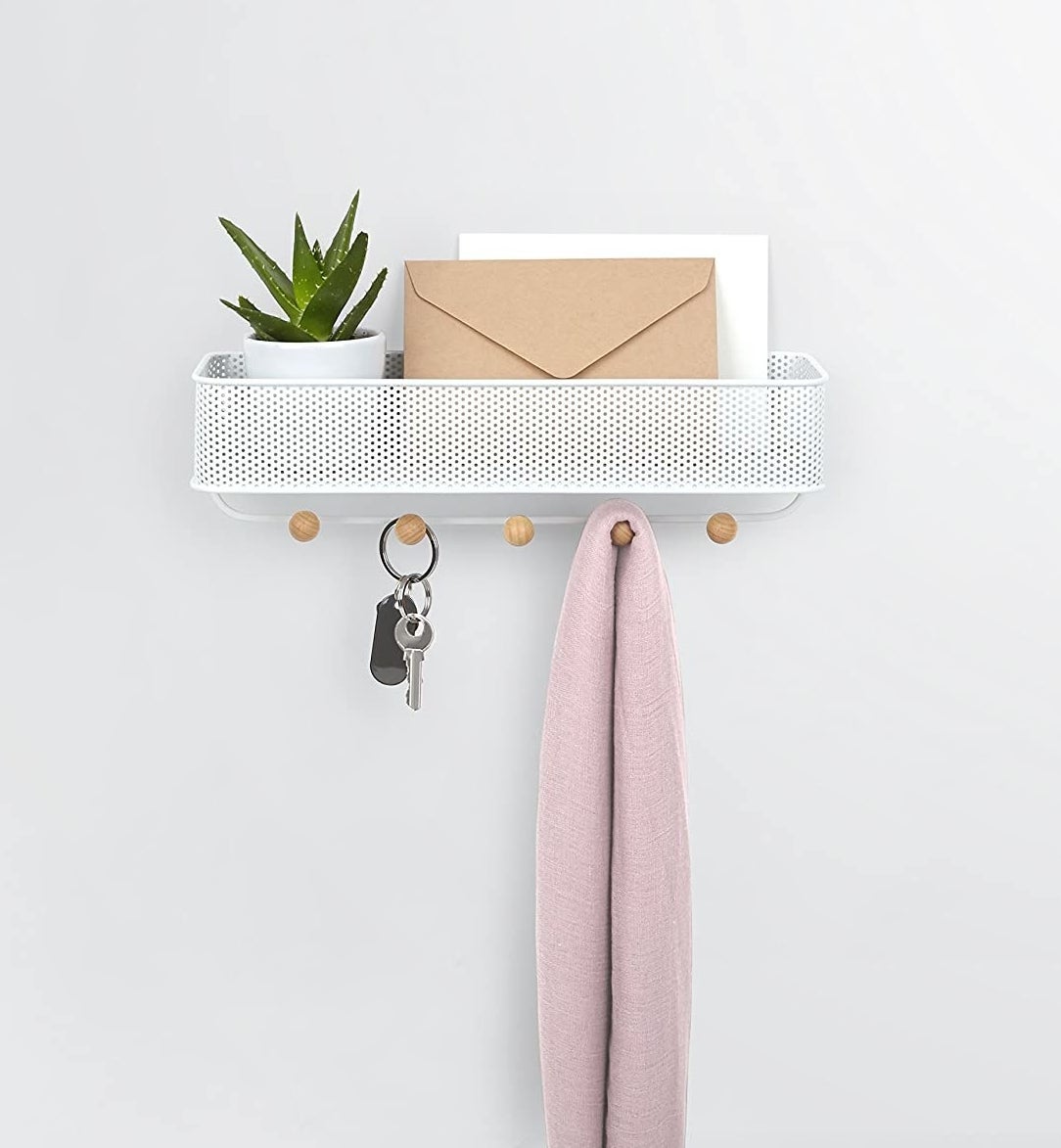 a sleek entryway organizer with five hooks and a shelf