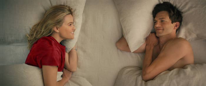 Ashton, on the right, lays in bed with Reese Witherspoon, on the left, in a scene from Your Place or Mine