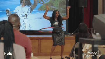 A character from Abbott Elementary uses a hula hoop at an assembly