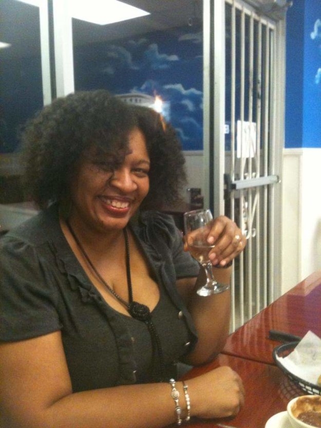 A woman smiling with a drink in her hands