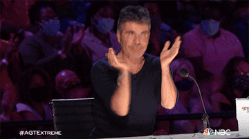 simon cowell giving two thumbs up and clapping