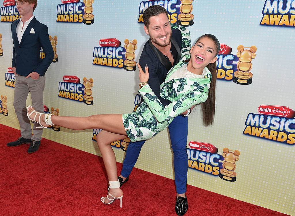 zendaya being dipped by her dance partner on the red carpet
