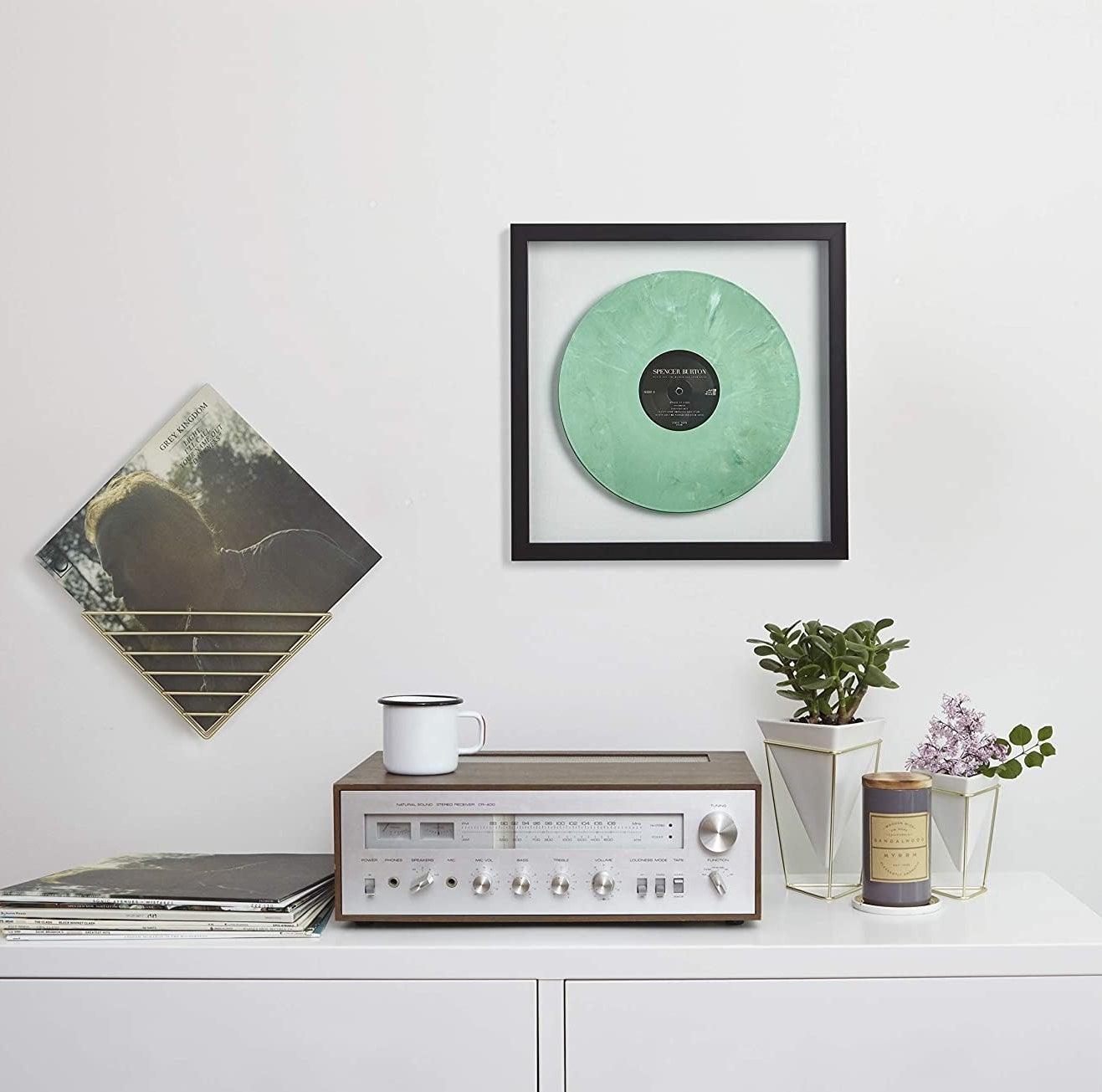 the frame on the wall over a table with a record player on it