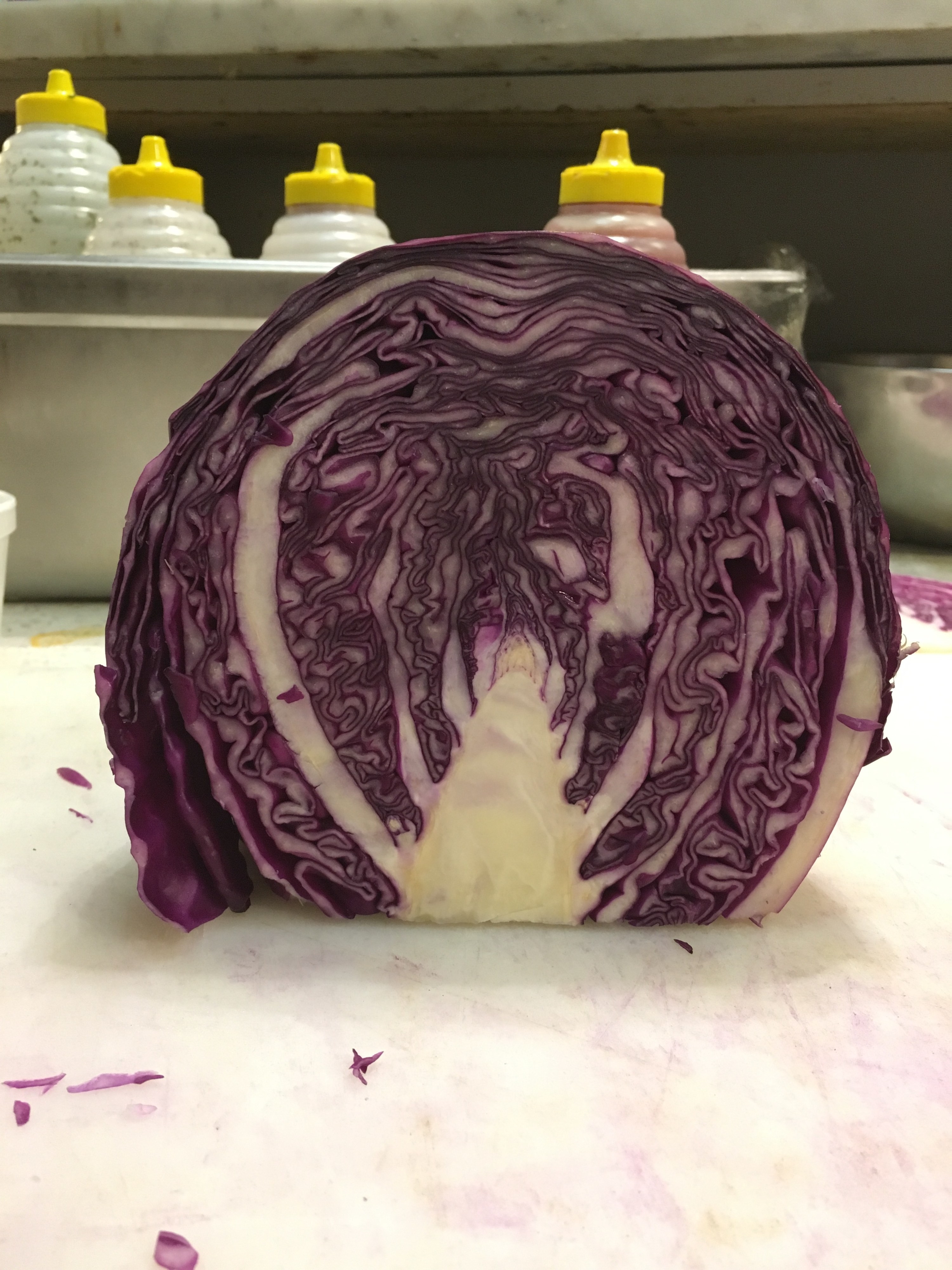 A red cabbage cut in half with the middle stalk looking like a long hallway floor