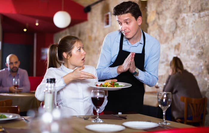 A woman complaining about her food to a waiter