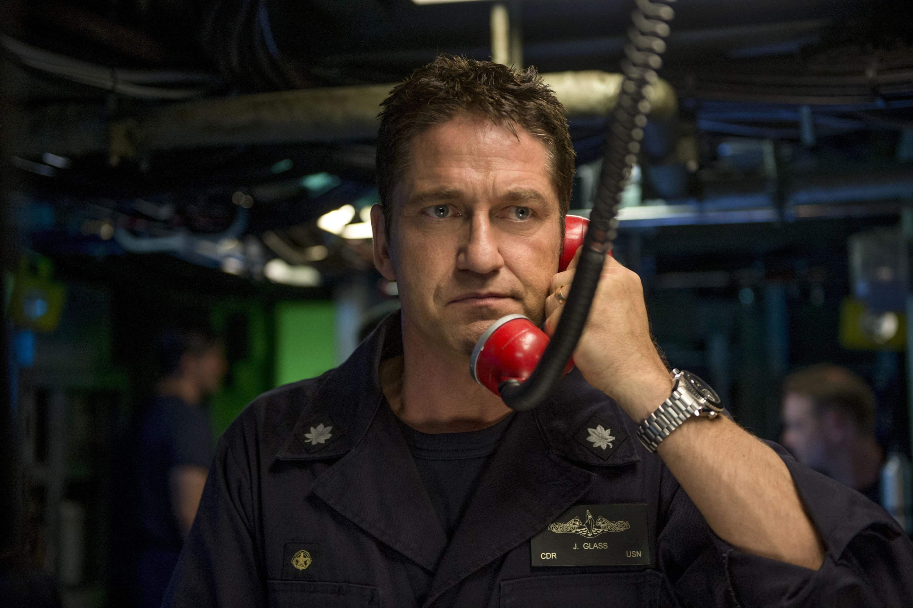 An intense submarine commander picks up a red telephone