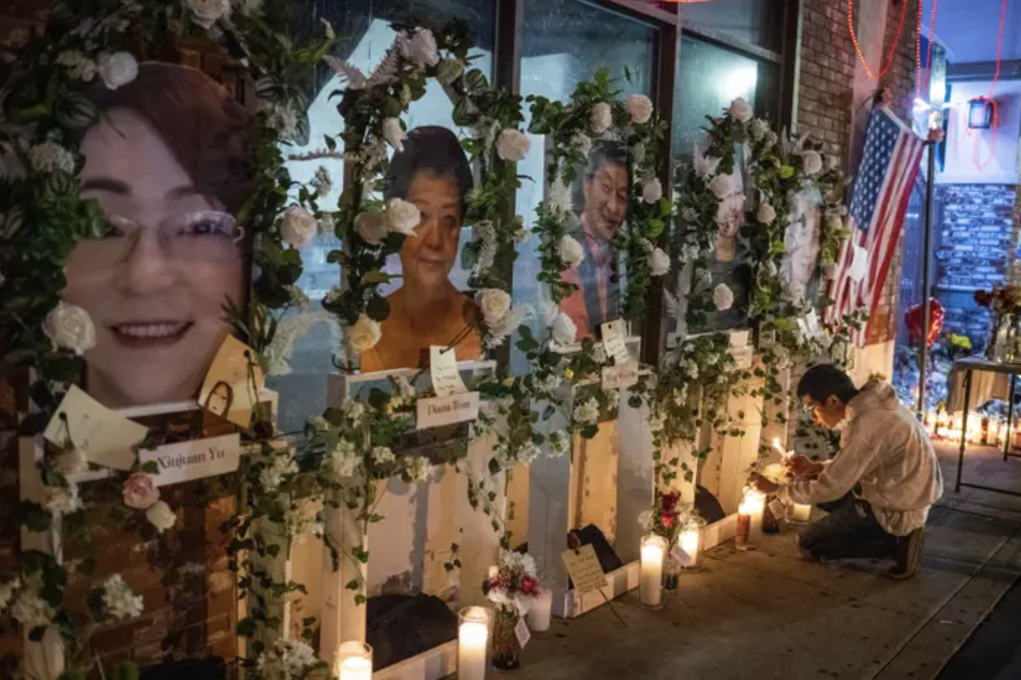 a vigil for the monterey park shooting victims; framed photos of the victims surroundeed by white roses and candles