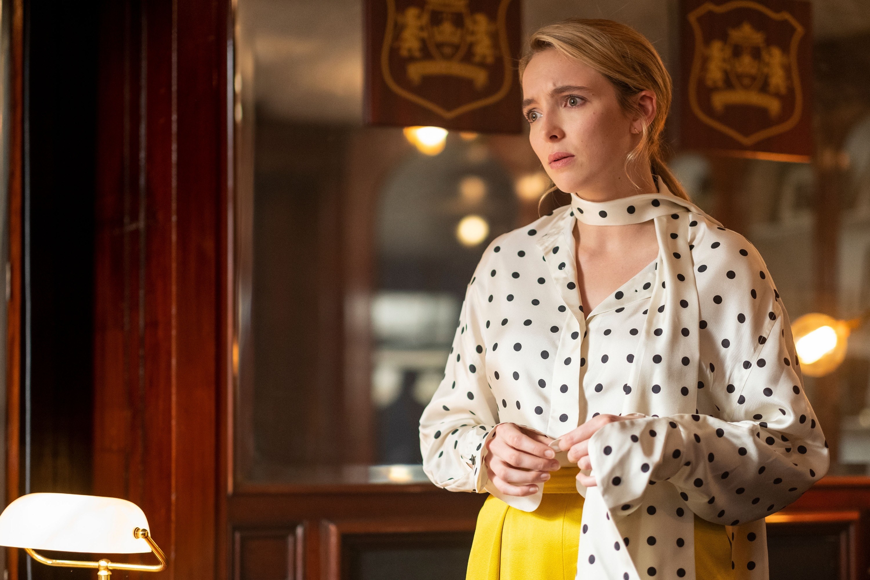 Jodie in the series wearing a black-dot blouse