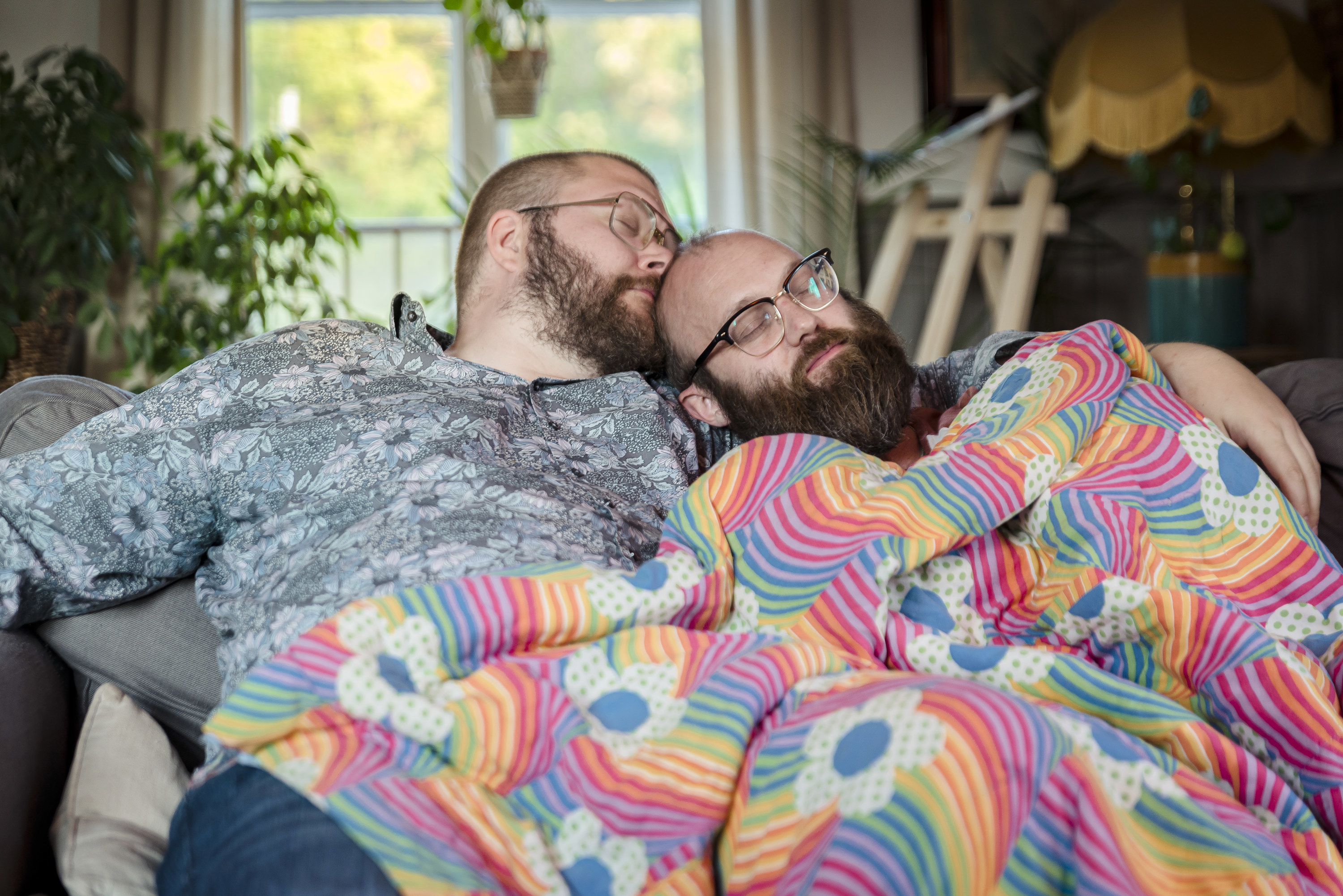 a couple cuddling on the couch together with a blanket