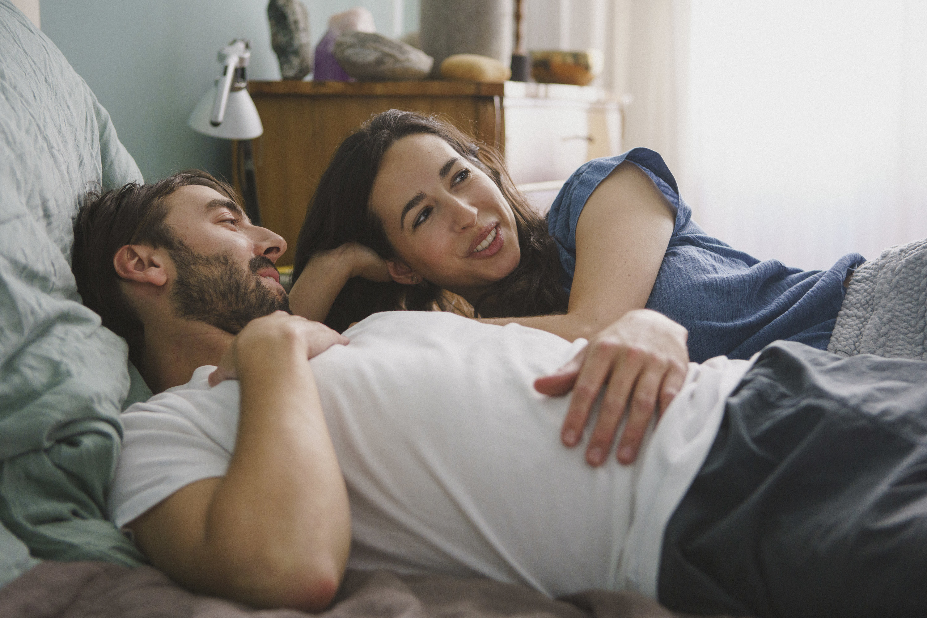 a couple in bed talking with one another