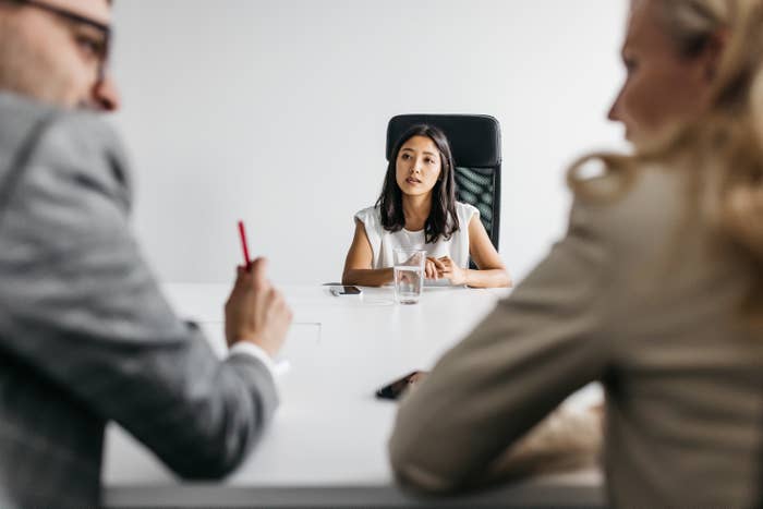 a woman in the middle of the interview with two employers