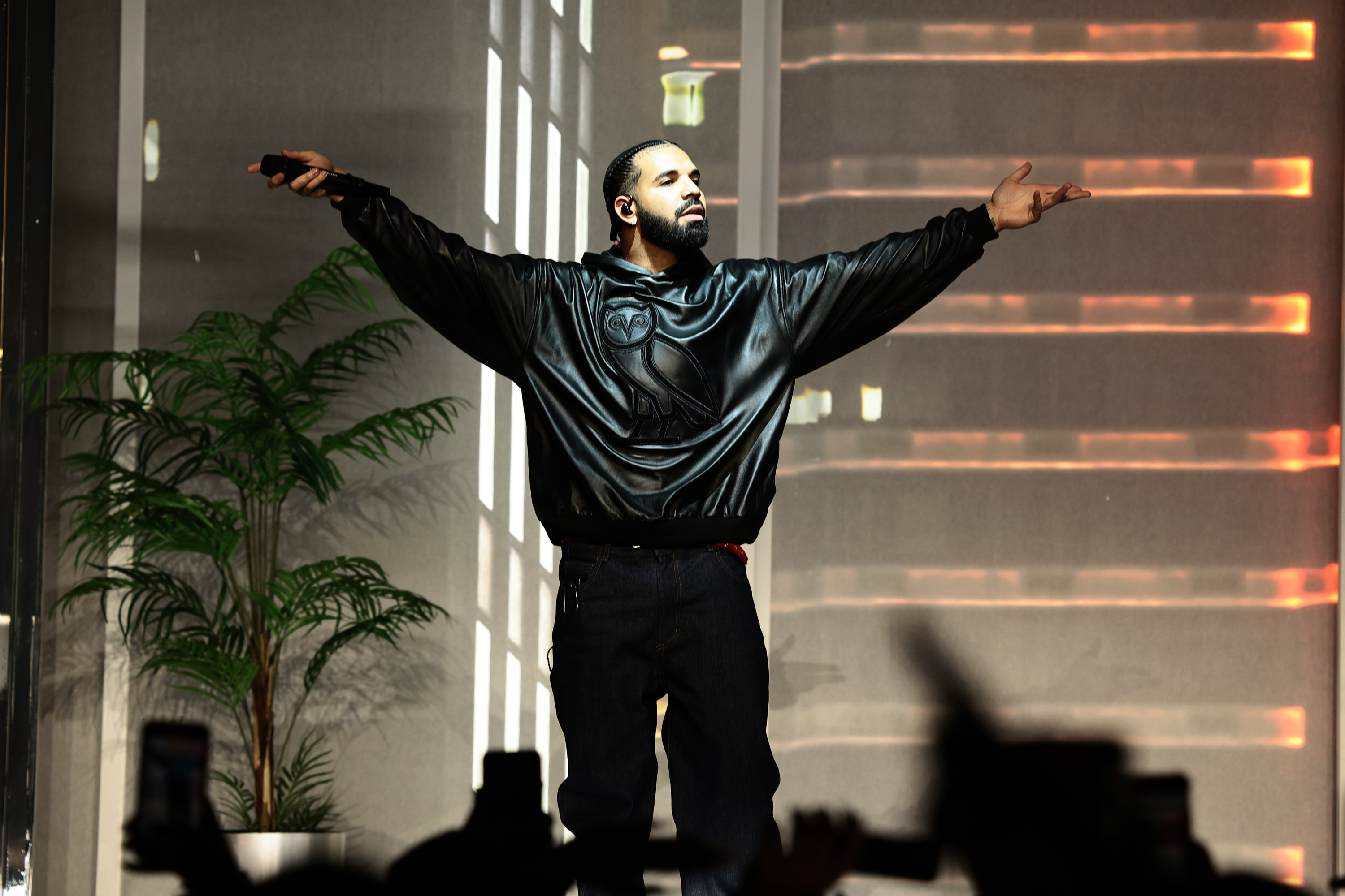 drake with his arms outreached on stage