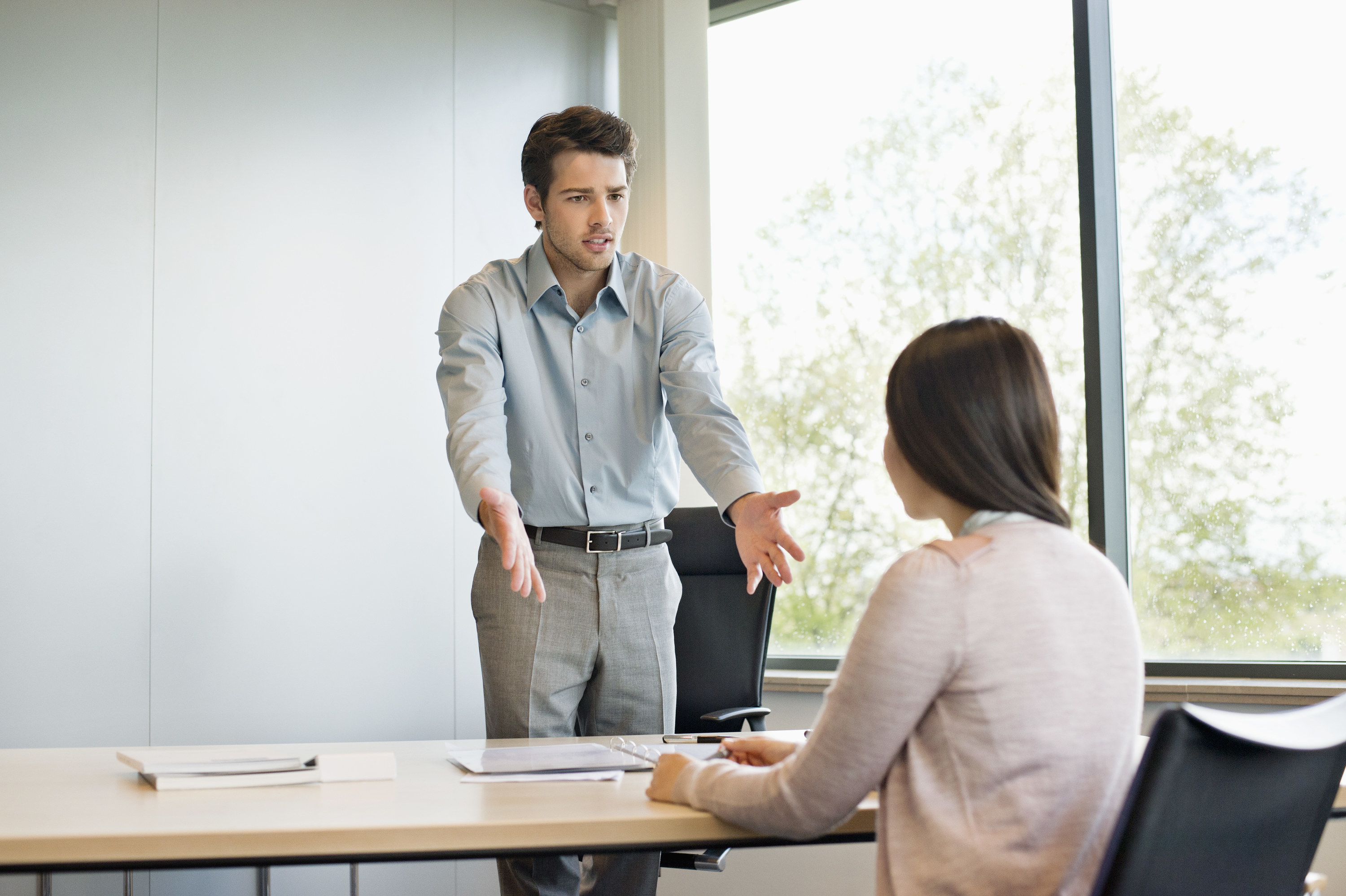 a man yelling at a woman while she's sitting