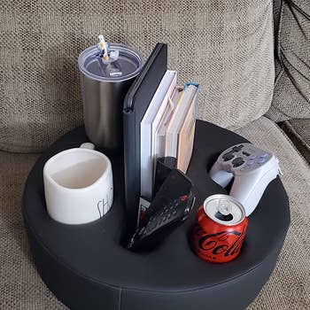 black couch caddy holding several items
