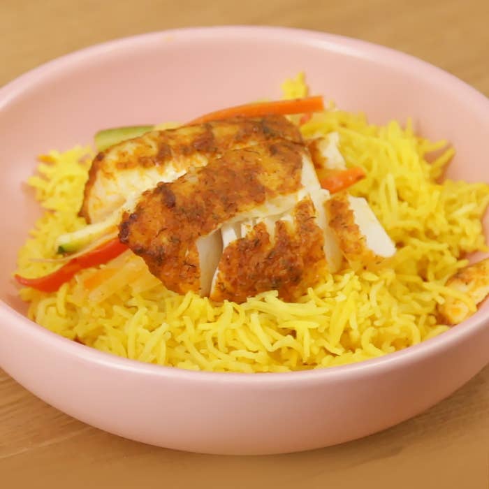 Pink bowl with fish and rice in it