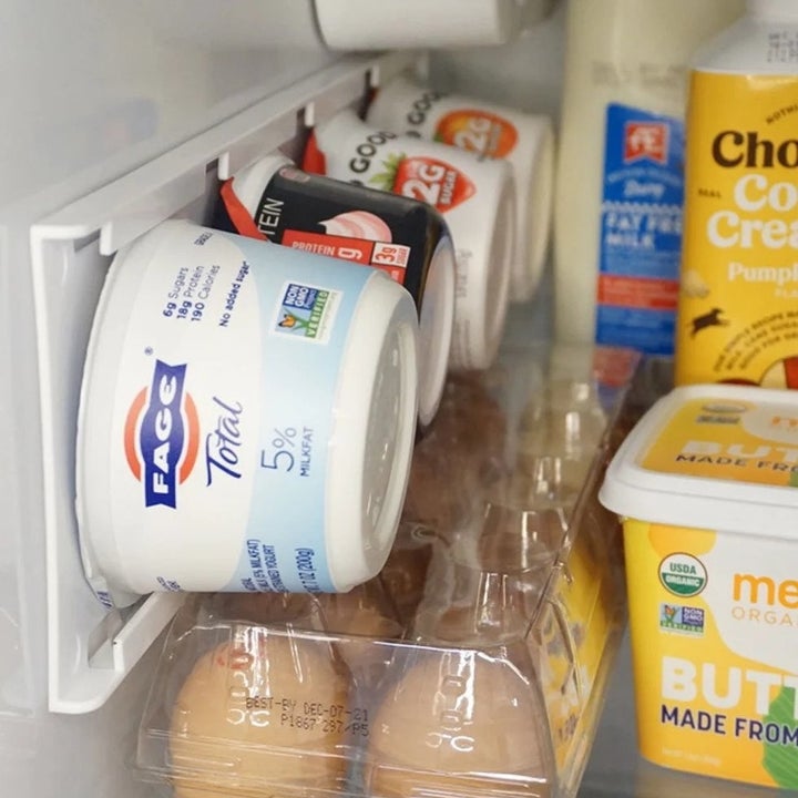 Four tubs of yogurt placed in yogurt holder inside fridge