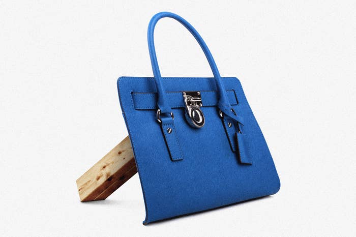 Blue handbag front propped up by wooden dowel.