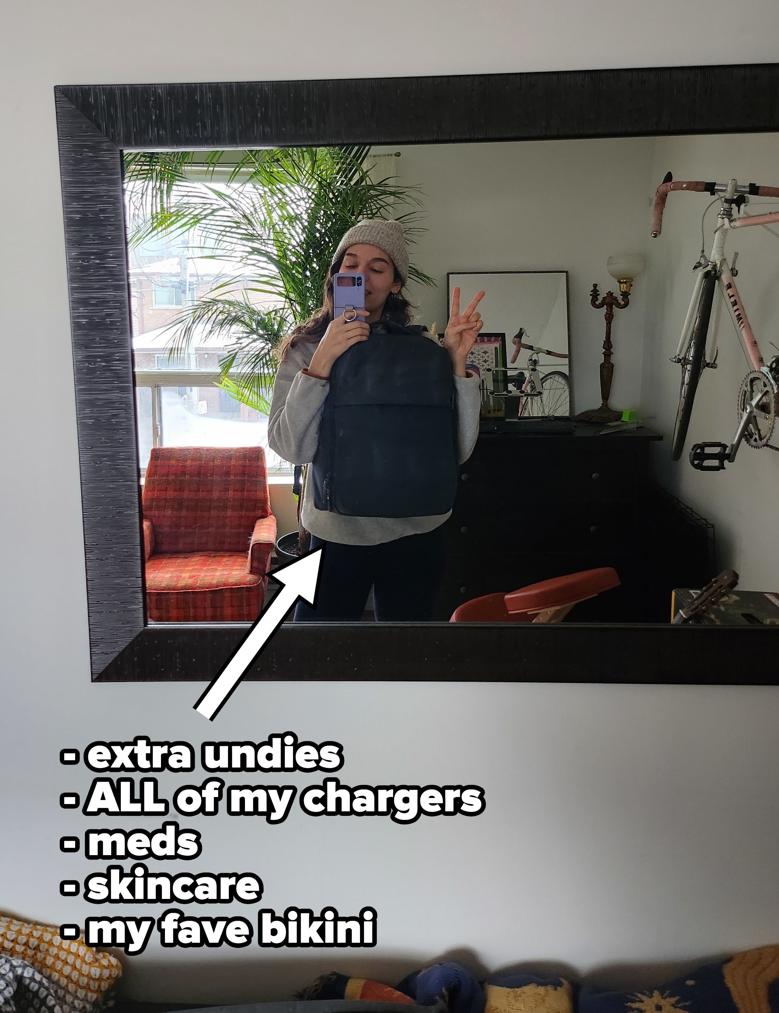 brittany in a mirror wearing her carry on bag