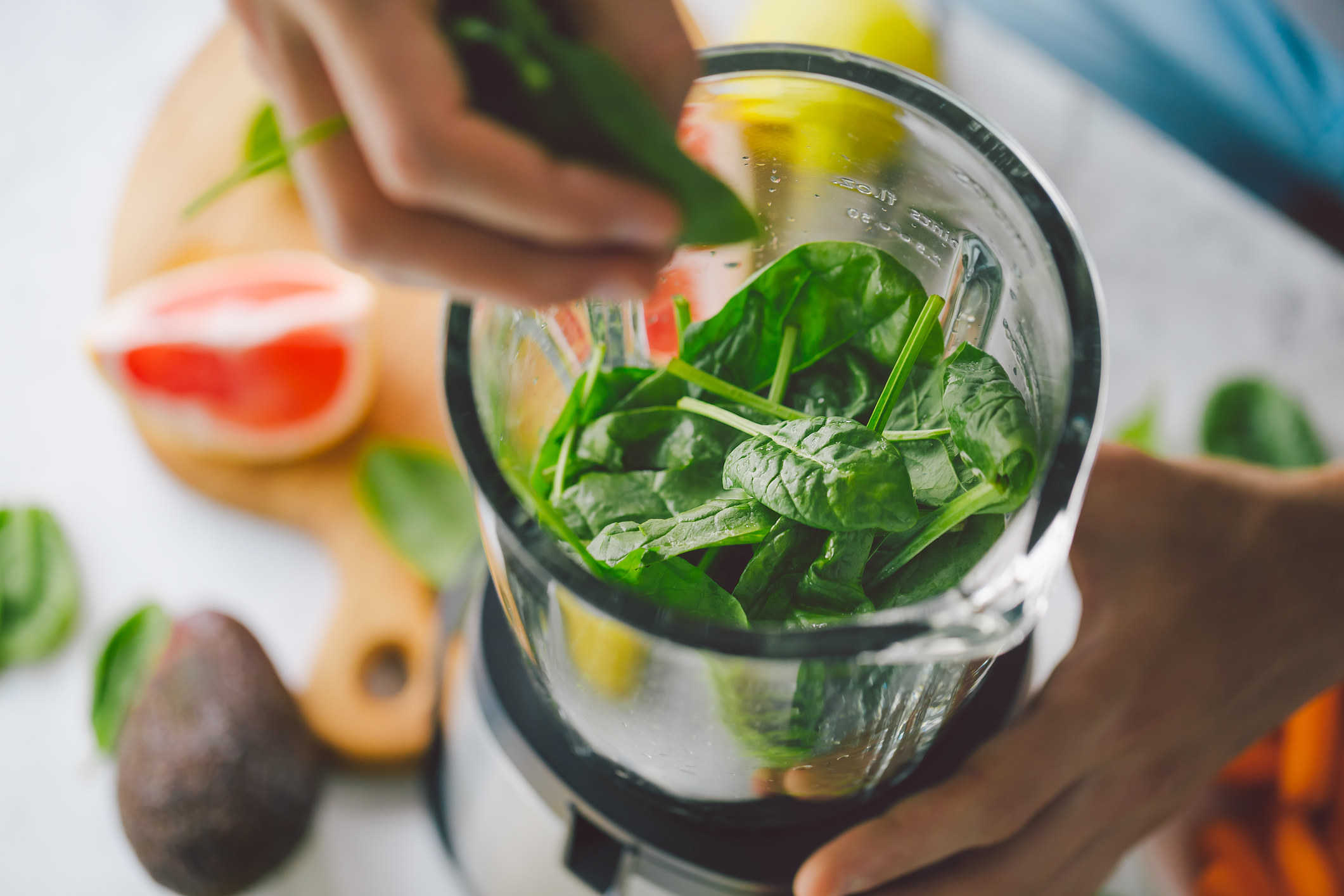 Adding fresh spinach to a blender