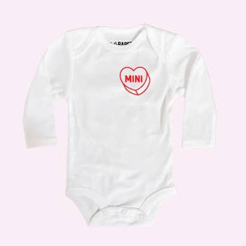 a baby body suit with a red candy heart on it that says mini