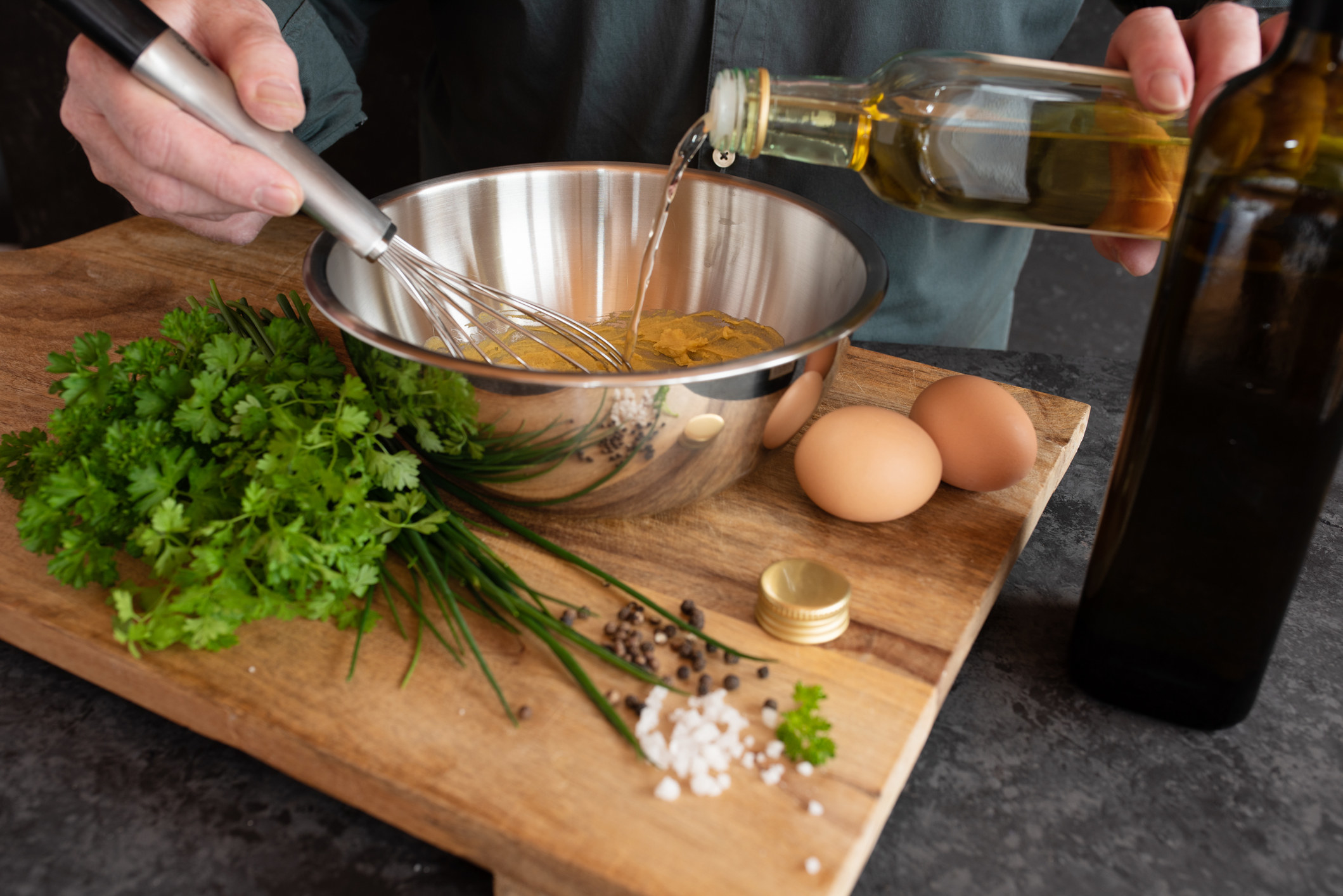 Preparing a sauce with vinegar and herbs.