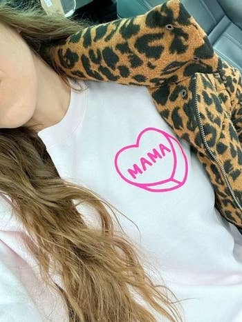 a white sweatshirt with a pink candy heart on it that says mama inside