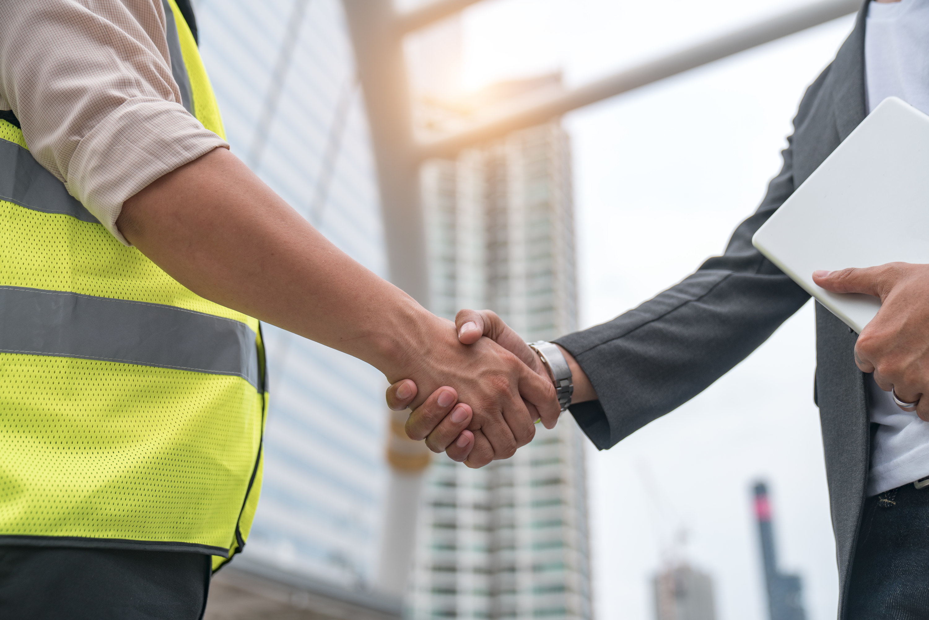man in business suit and construction worker shaking hands