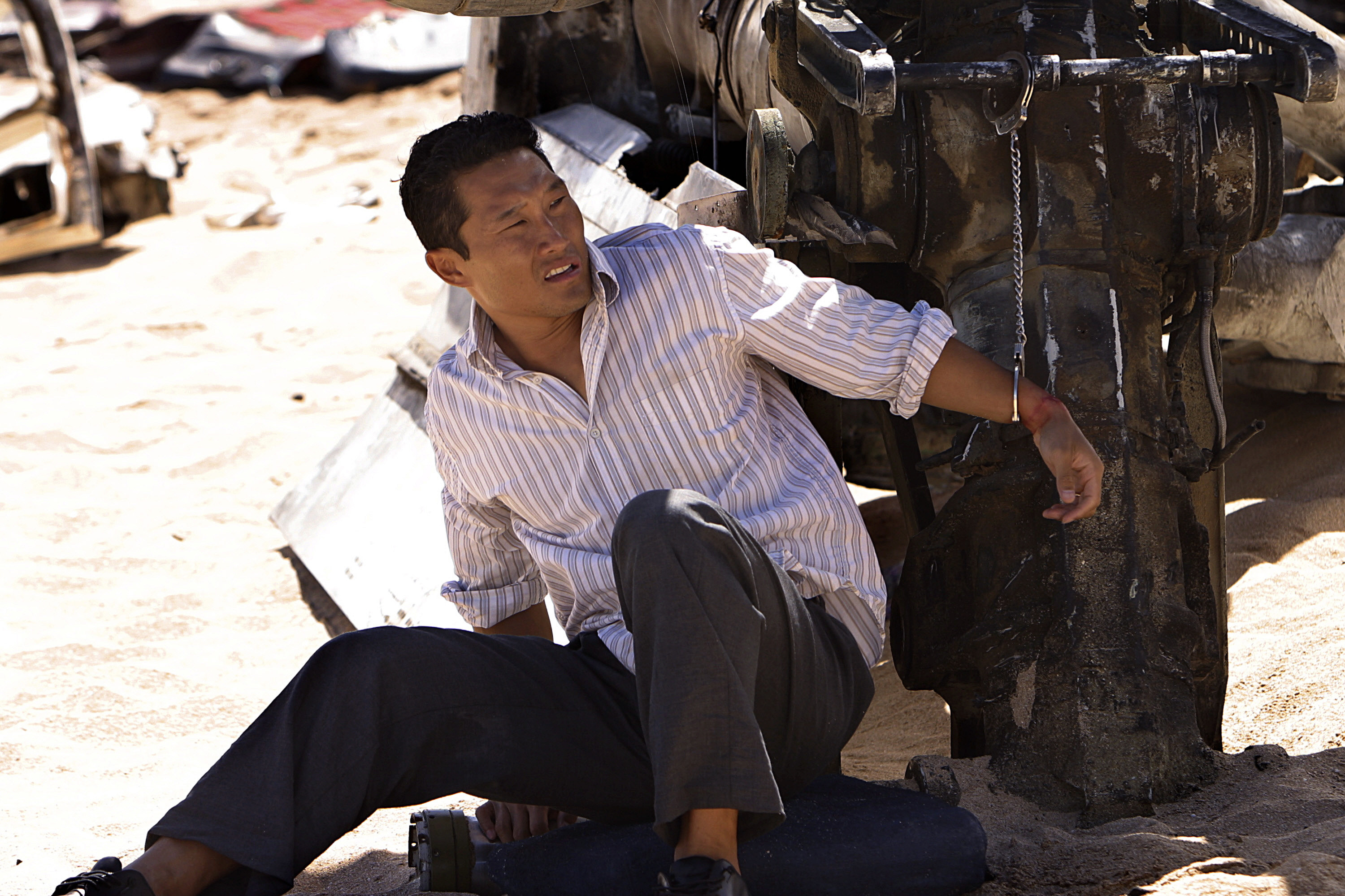 Daniel sitting on sand in a scene from Lost