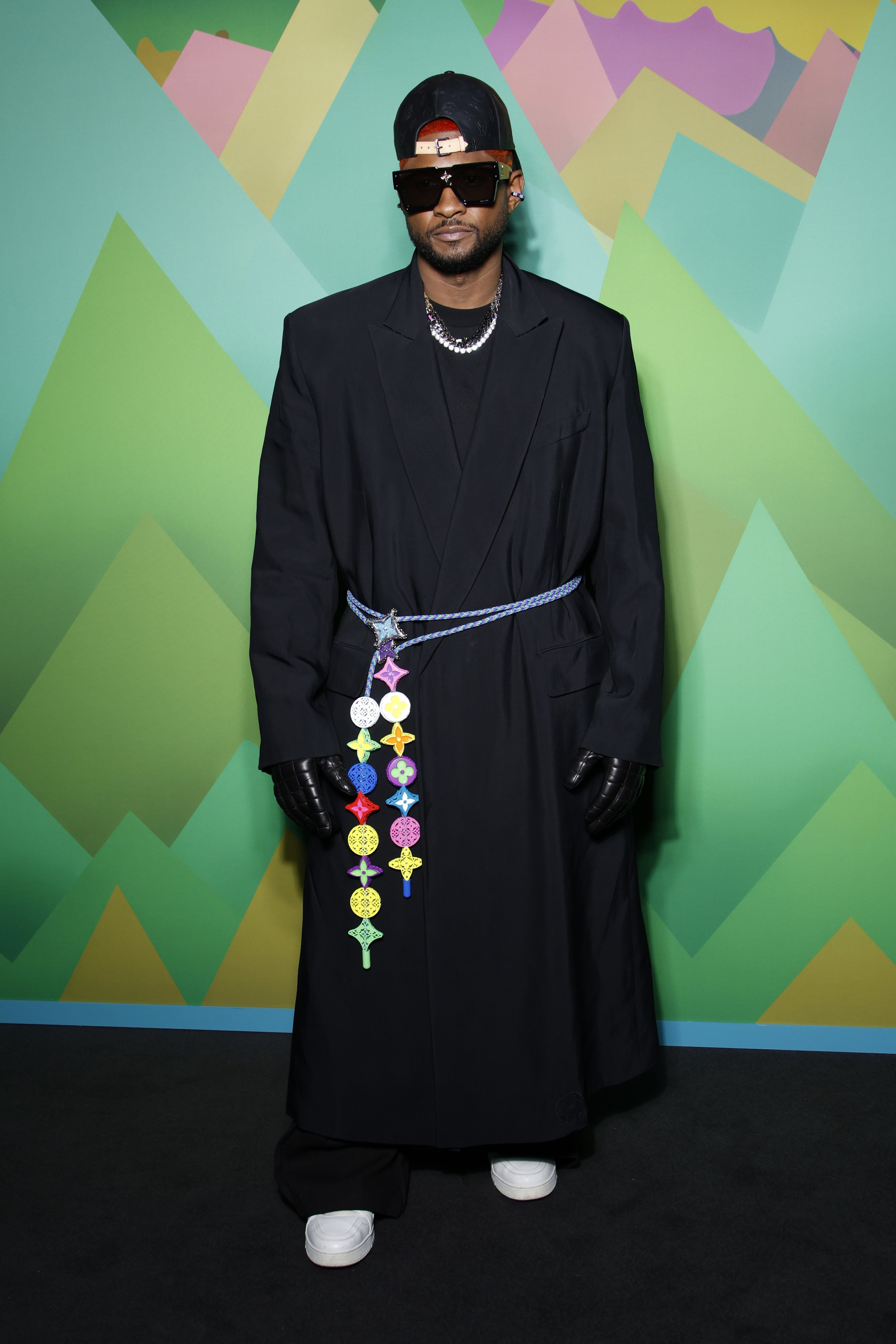 usher wearing a floor-length blazer coat tied with an ornamental belt