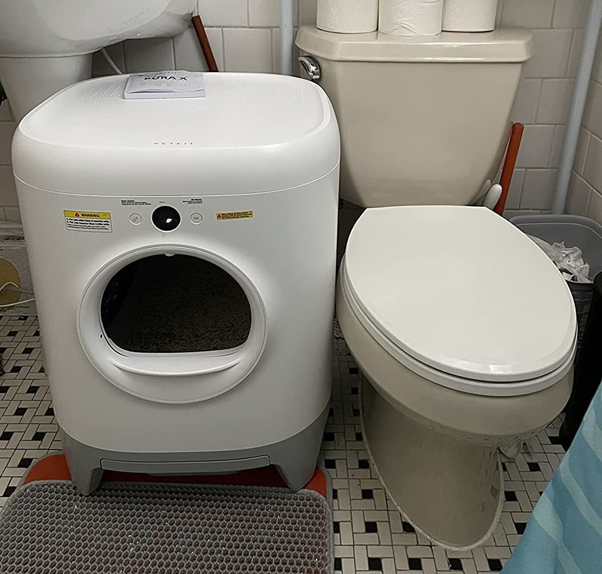the automatic cleaner next to toilet in bathroom