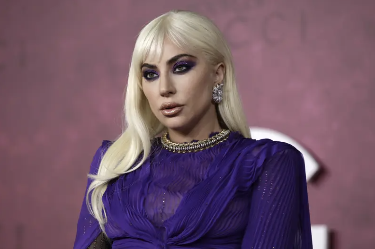 Lady Gaga looks beyond the camera in purple