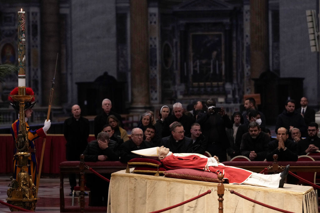 The body of Pope Emeritus Benedict XVI  lies in state as mourners in black look on