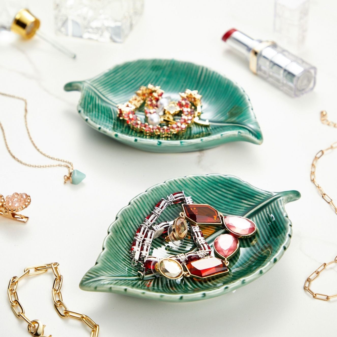 the two leaf trays holding jewelry